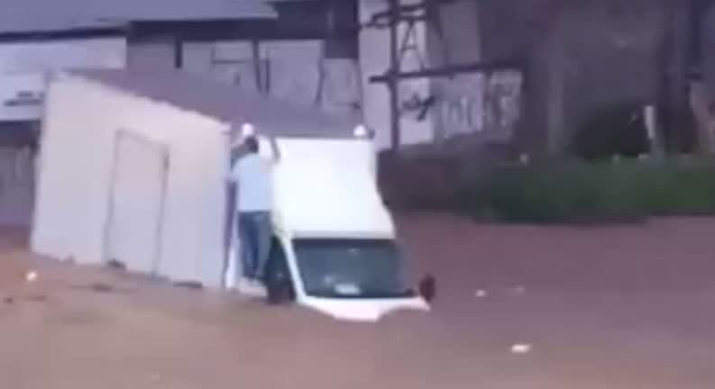 Vídeo: Homem fica pendurado em cabine de caminhão durante enchente